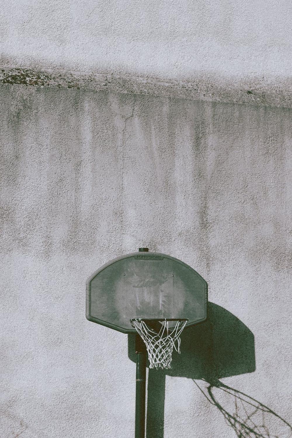 basketball_hoop_near_weathered_wall_on_sports_grou